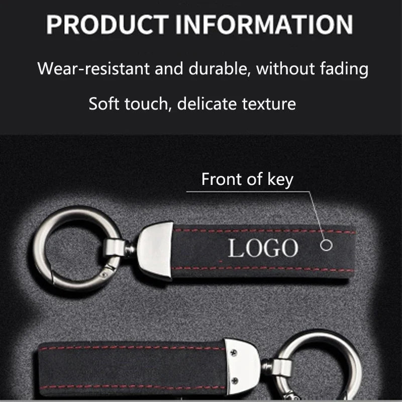 A close-up view of a black suede leather car keychain with a silver logo and stitching.