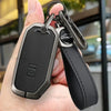 A black durable zinc alloy key fob cover attached to a leather strap, held in a hand.