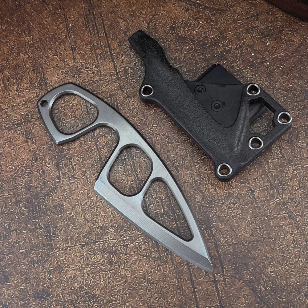 A durable stainless steel fixed blade survival knife with a black handle resting on a wooden surface.