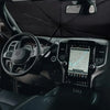 Interior view of a car showing a retractable sunshade deployed on the windshield.