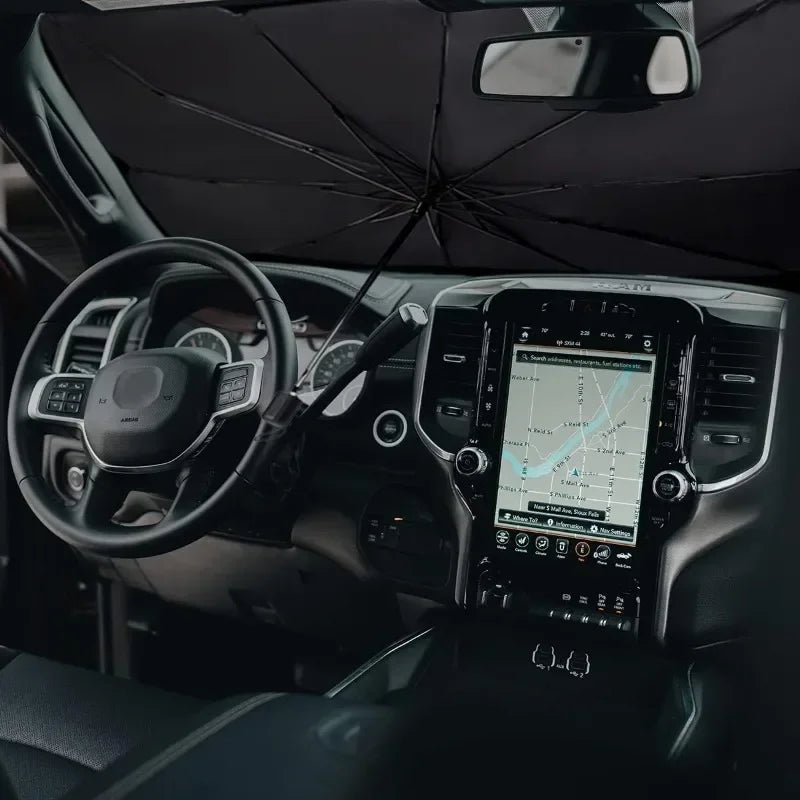 Interior view of a car showing a retractable sunshade deployed on the windshield.