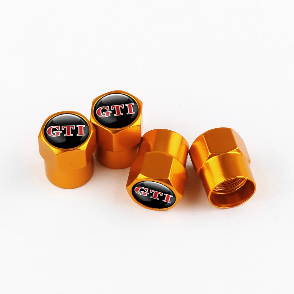 Four metallic orange tire valve caps with black and red GTI lettering