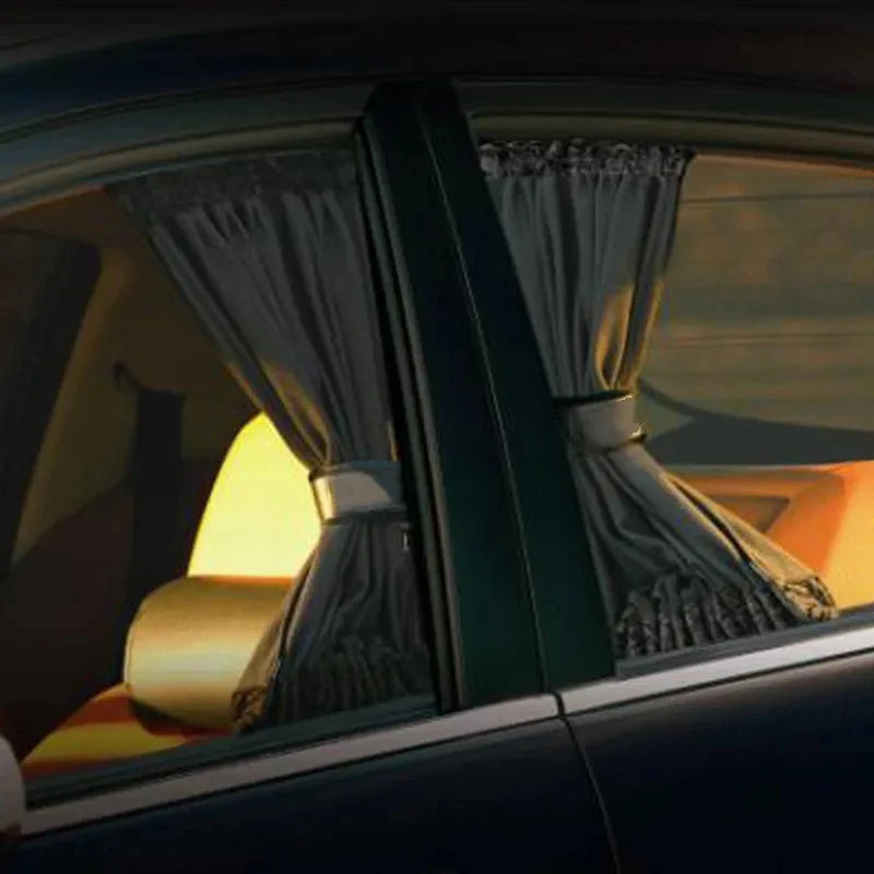 A close-up view of a car window with a pleated sun shade curtain partially drawn.