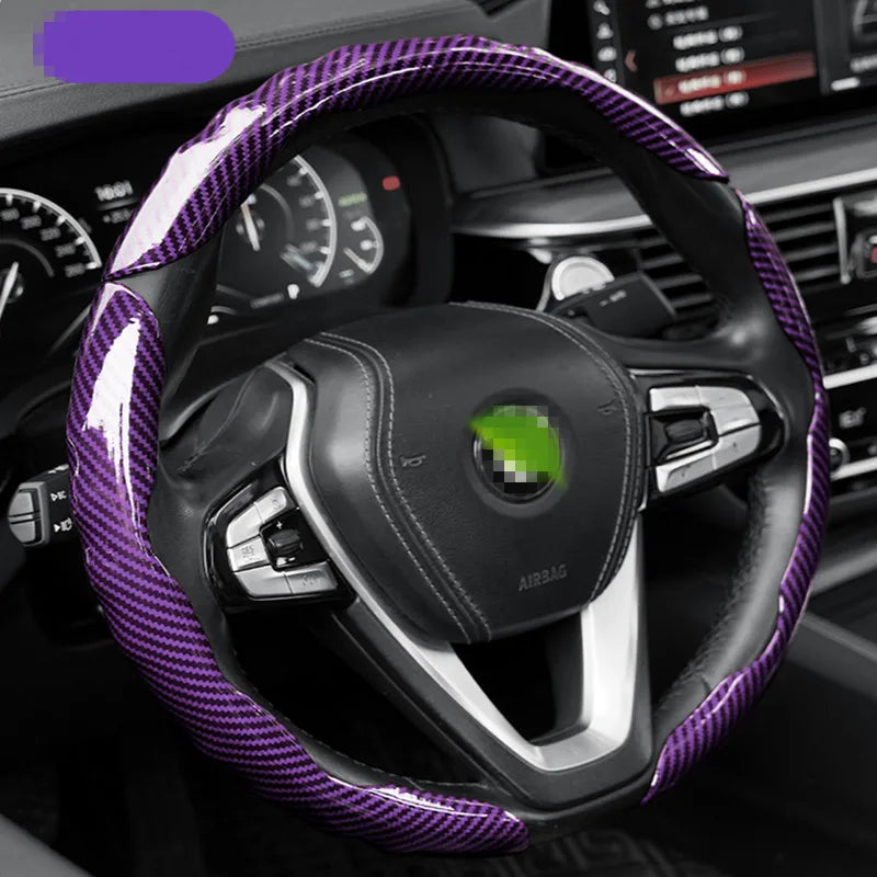 Volant noir recouvert d'un protecteur en fibre de carbone violette, montrant le logement de l'airbag.