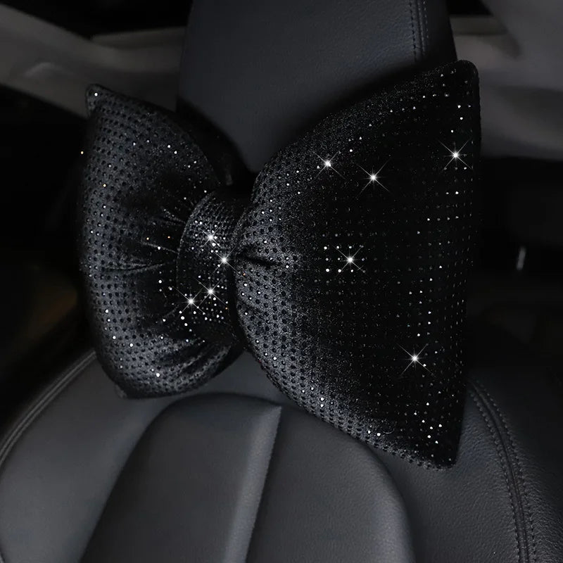 Almohada de cuello para coche de cristal de imitación negro con pedrería, atada en un lazo, sobre tapicería de cuero gris osc