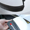 A close-up of a black and white car side mirror rain deflector set being held by a hand.