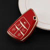 A red multi-function car key cover rests on a white plate.