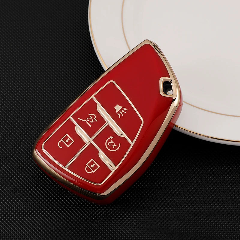 A red multi-function car key cover rests on a white plate.