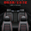 A close-up view of black leather car seat covers with red stitching installed in a vehicle interior.