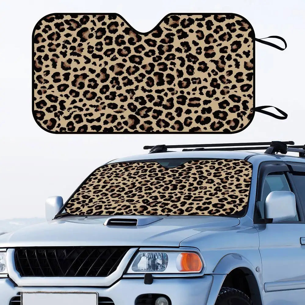 Leopard print car sunshade fitted onto the windshield of a silver truck.