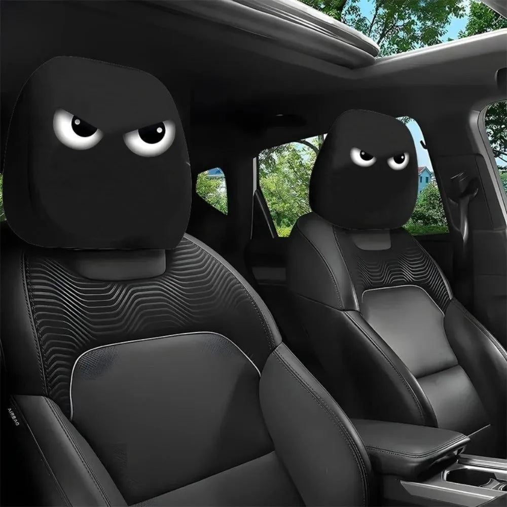 Black car seat headrest covers with a decorative pattern installed in a vehicle interior.