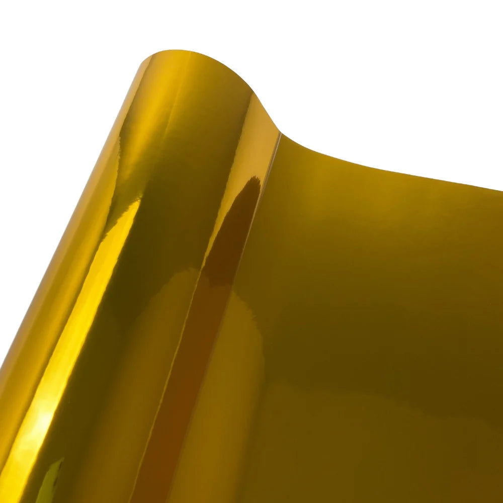 Close-up view of a smooth, golden yellow gloss chrome vinyl car wrap film surface.
