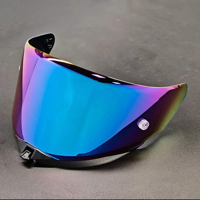 A glossy blue motorcycle helmet visor with a purple iridescent finish displayed on a dark surface.