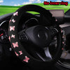Cubierta del volante negra con estampado de mariposa rosa brillante instalada en el interior de un coche.