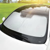 Un pare-soleil de voiture haut de gamme est installé sur une voiture blanche, visible de l'avant.