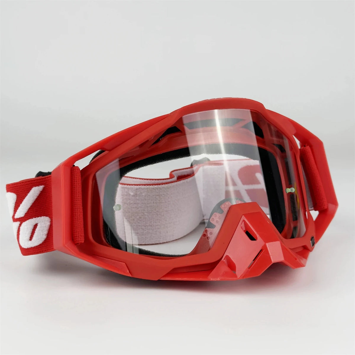 Red all-weather off-road motorcycle riding goggles with clear lenses and a protective frame