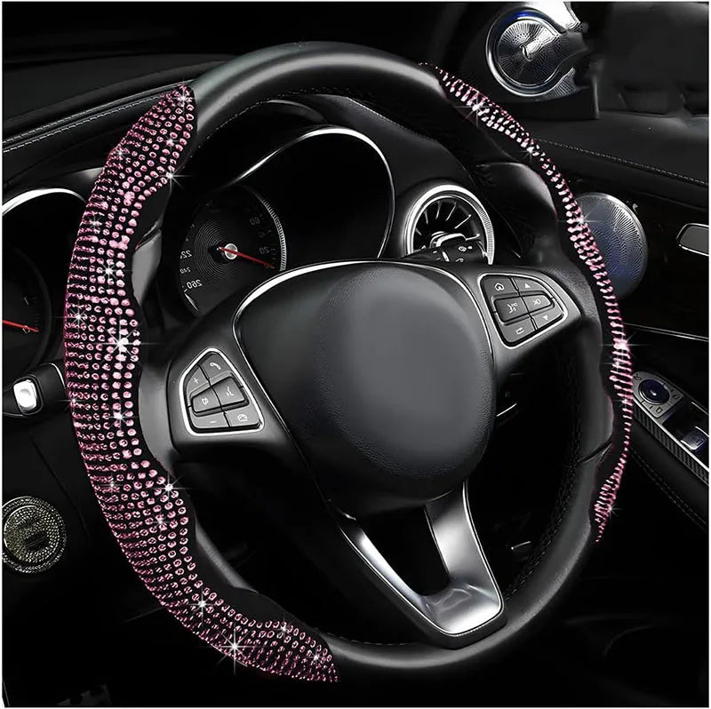 Volant noir avec garniture rose sertie de diamants et intérieur en cuir visible dans l'habitacle d'une voiture.