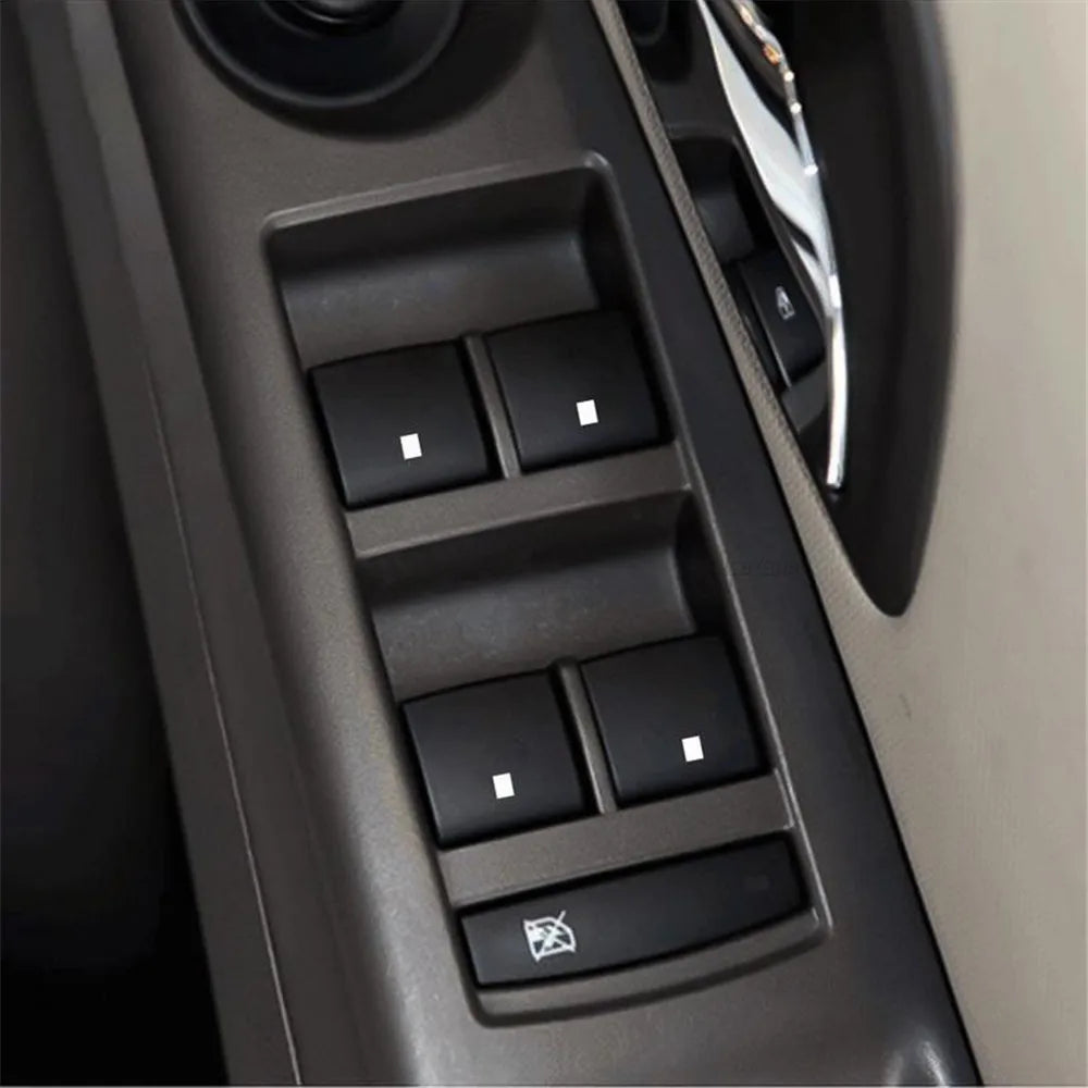 Nahaufnahme des Ersatzmoduls für ein Auto-Fensterheber, mit mehreren Tasten und silberner Verkleidung.