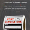 Roll of oil change reminder stickers showing date and mileage information