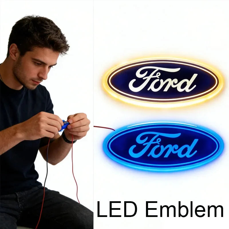 A man is holding a glowing blue LED emblem for a Ford vehicle.