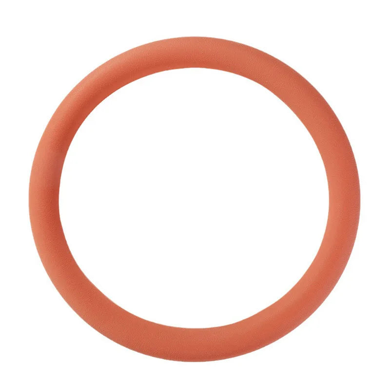 A circular, thin silicone steering wheel cover in a coral or peach color.