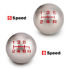 Two aluminum gear shift knobs showing speed markings, one labeled 5 Speed and the other 6 Speed.