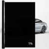 A close-up view of a black car window privacy film applied to a silver car.