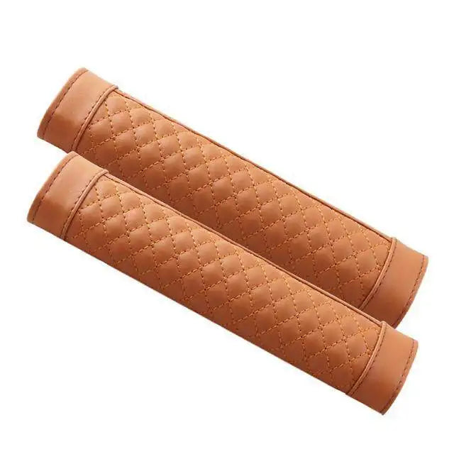 A pair of brown quilted PU leather car seat belt covers rolled up.