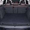 A dark gray car trunk mat with a rhombus pattern is shown inside a vehicle with leather seats.