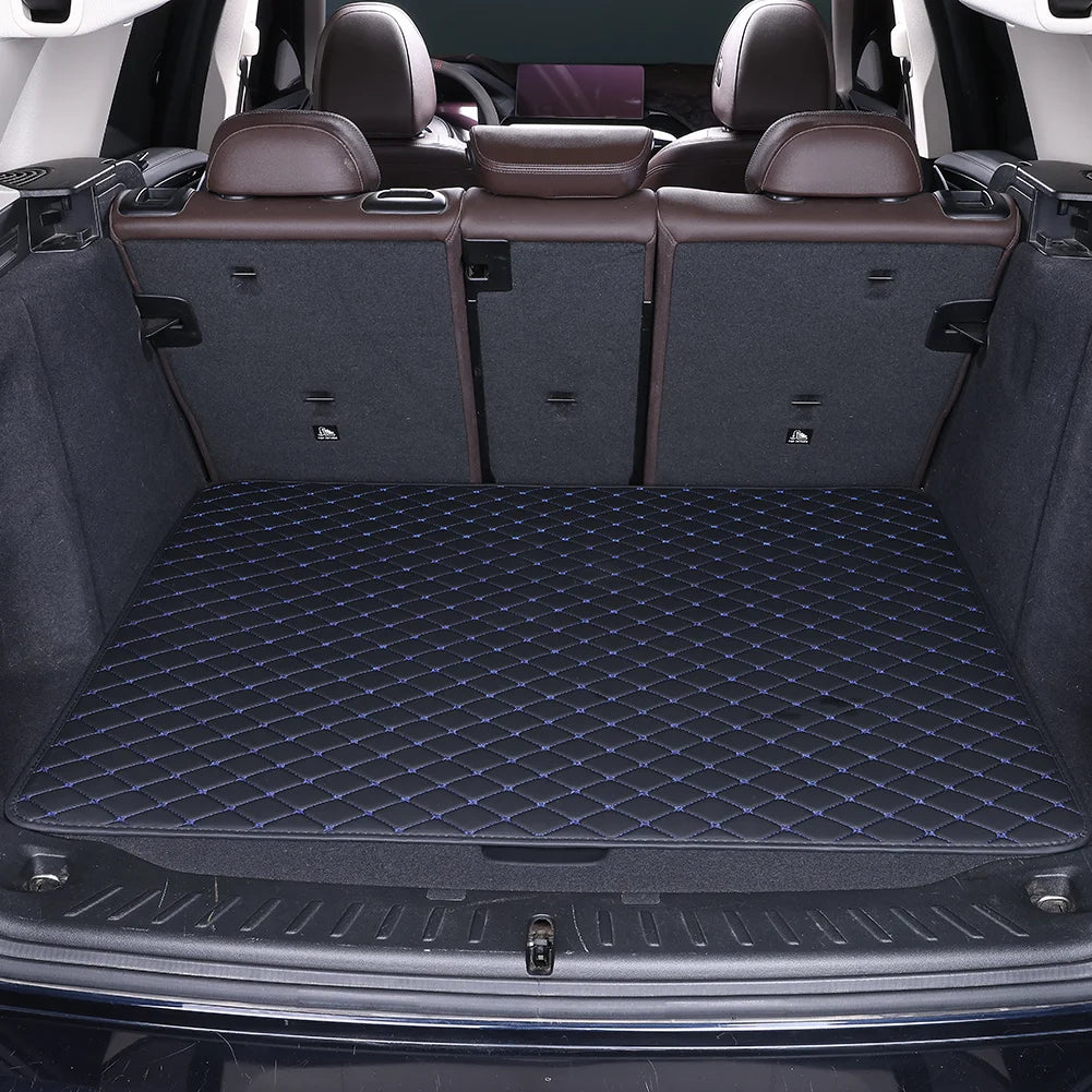 A dark gray car trunk mat with a rhombus pattern is shown inside a vehicle with leather seats.