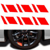Calcomanías reflectantes rojas aplicadas al cubo de una rueda de coche.