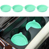 A set of four light green silicone cup holder coasters shown in a close-up view inside a car cup holder.