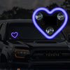 Un véhicule Toyota noir avec une décoration lumineuse en forme de cœur sur le pare-brise.
