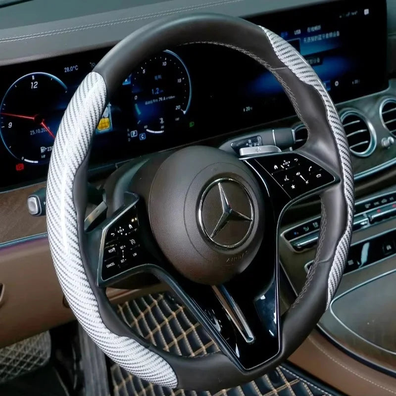 Nahaufnahme eines schwarzen Lenkrads mit silber-weiß gemustertem Überzug in der Auto-Innenausstattung.