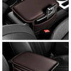 A dark brown leather storage organizer pad is placed in the armrest of a car seat.