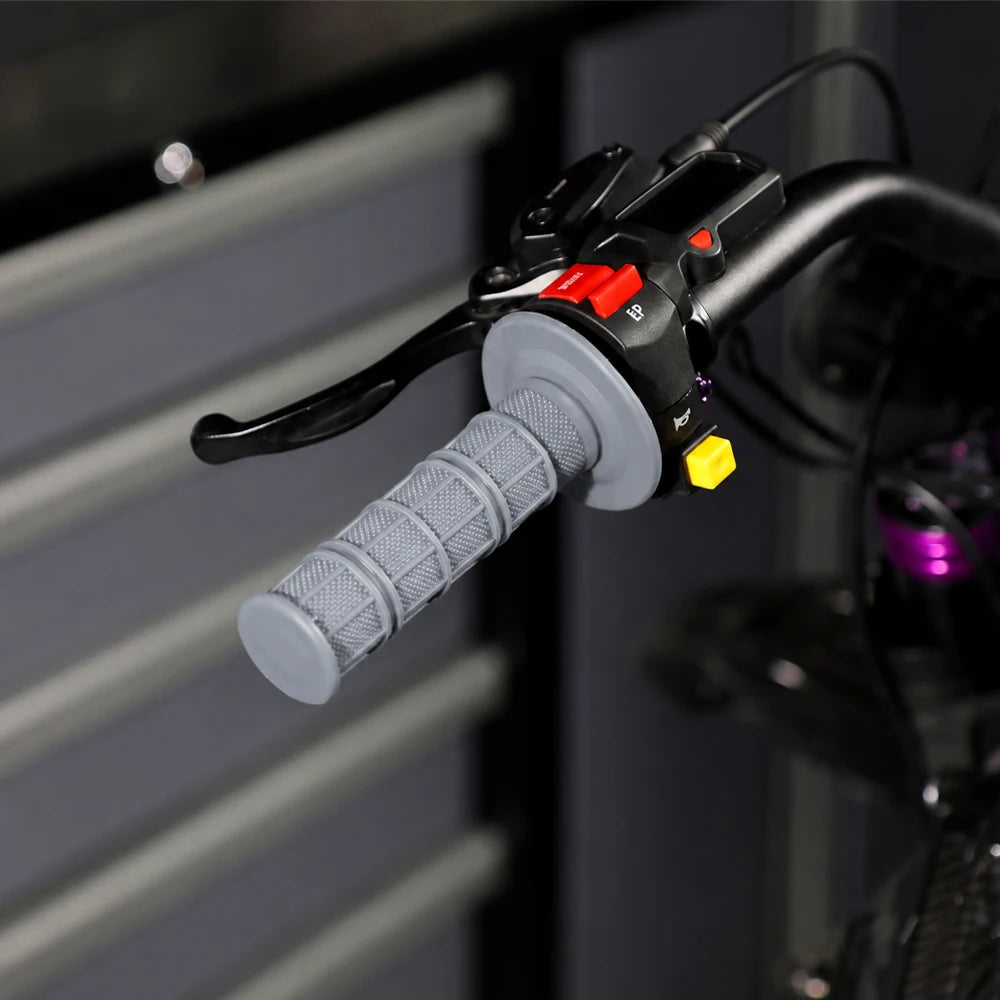 Close-up of black silicone handle bar grips with a textured gray grip and red/yellow indicator lights.