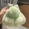 A light green plush bunny keychain with soft fur and a gold ring.