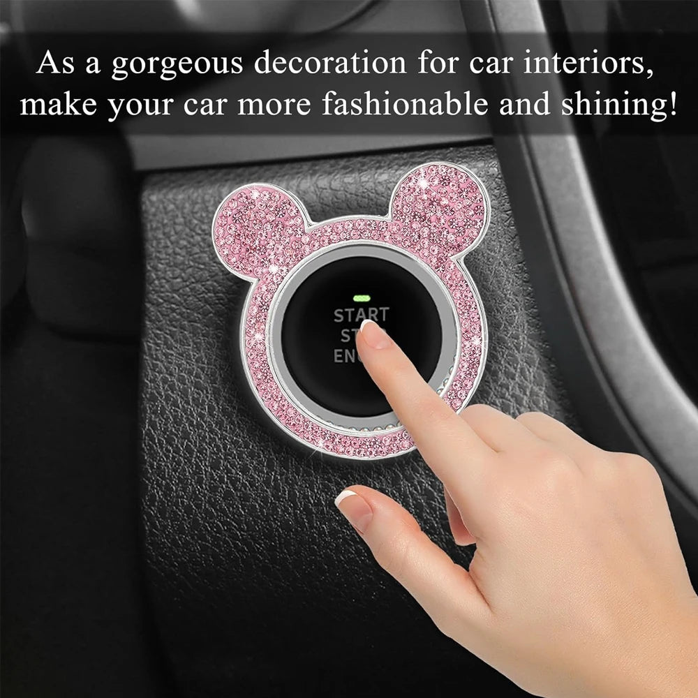 Una mano presiona la tapa de la ignición de un coche brillante rosa con diseño de oso en un panel interior.