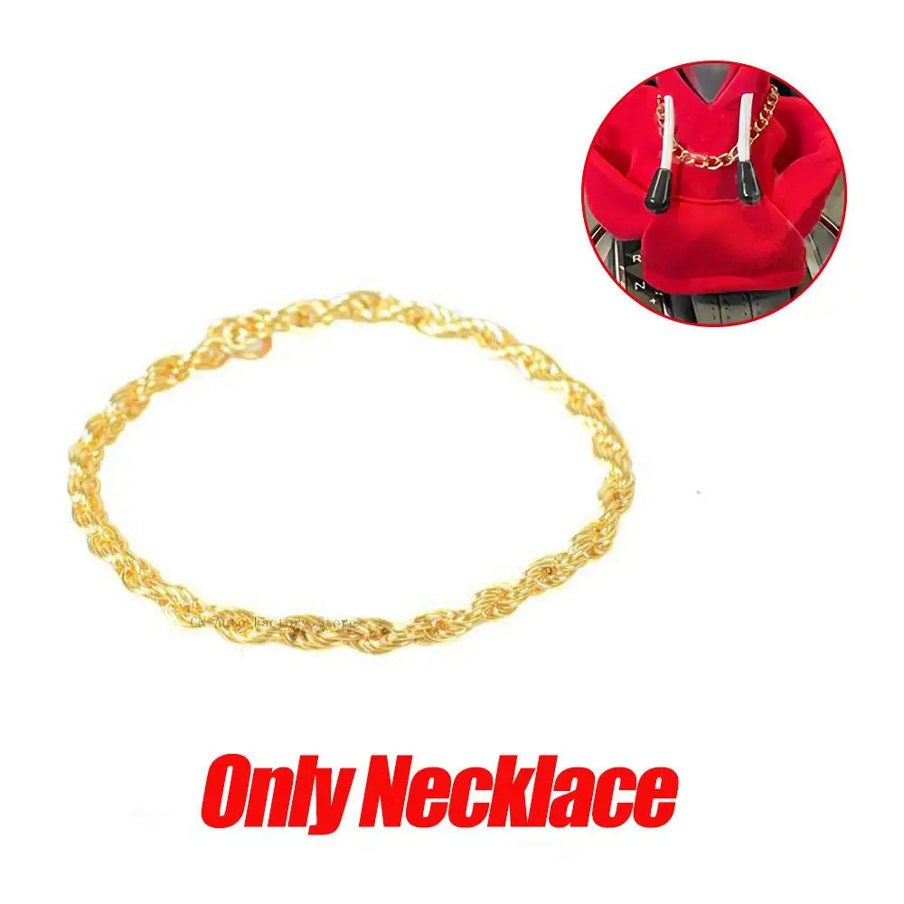 Gold chain necklace displayed next to a red hoodie cover.