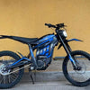 A blue and black motorcycle kit featuring a mudguard and protection system parked against a yellow wall.