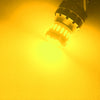 A close-up view of a bright yellow LED brake and reverse light bulb illuminating a surface.