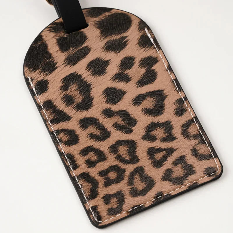 A brown leopard print passport holder with card slots attached to a black strap.
