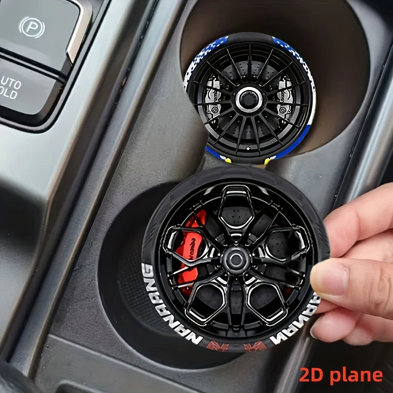 Close-up of two black silicone coasters with racing wheel hub designs inside a car console.