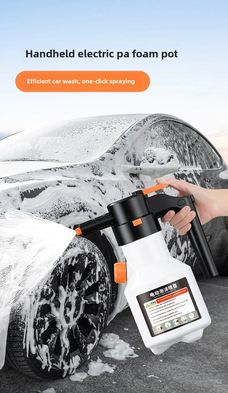 A hand is using a white handheld electric foam pot to wash snow off a car tire.