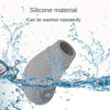 A gray silicone car gear shift knob and handbrake cover set being washed under water.