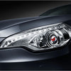 Close-up of a dark gray car's modern headlight assembly with clear lenses and internal reflectors.