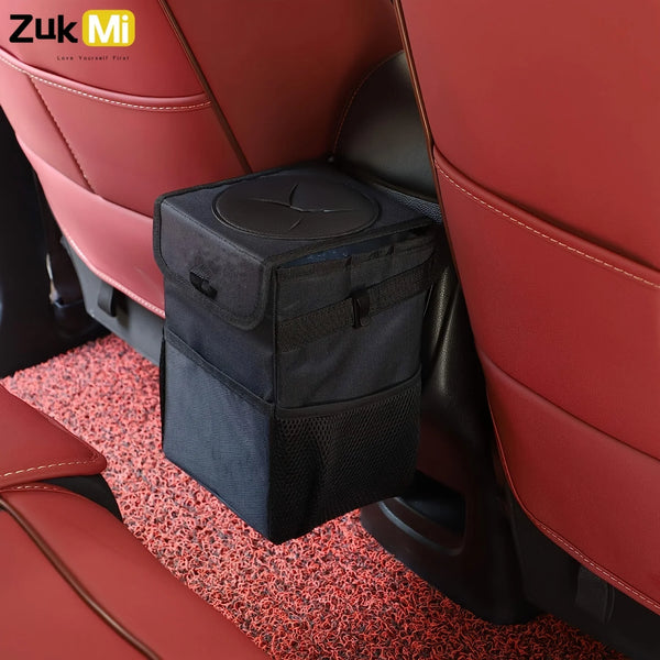 A black collapsible car trash can organizer is placed in the seat of a red car interior.