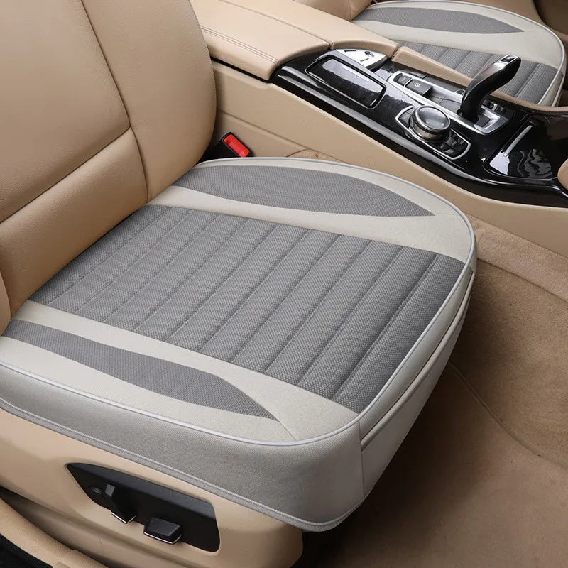 Tan car seat covers with gray fabric and black trim shown in a vehicle interior.