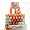 A set of colorful cartoon keycap stress relief buttons arranged in a rectangular tray.