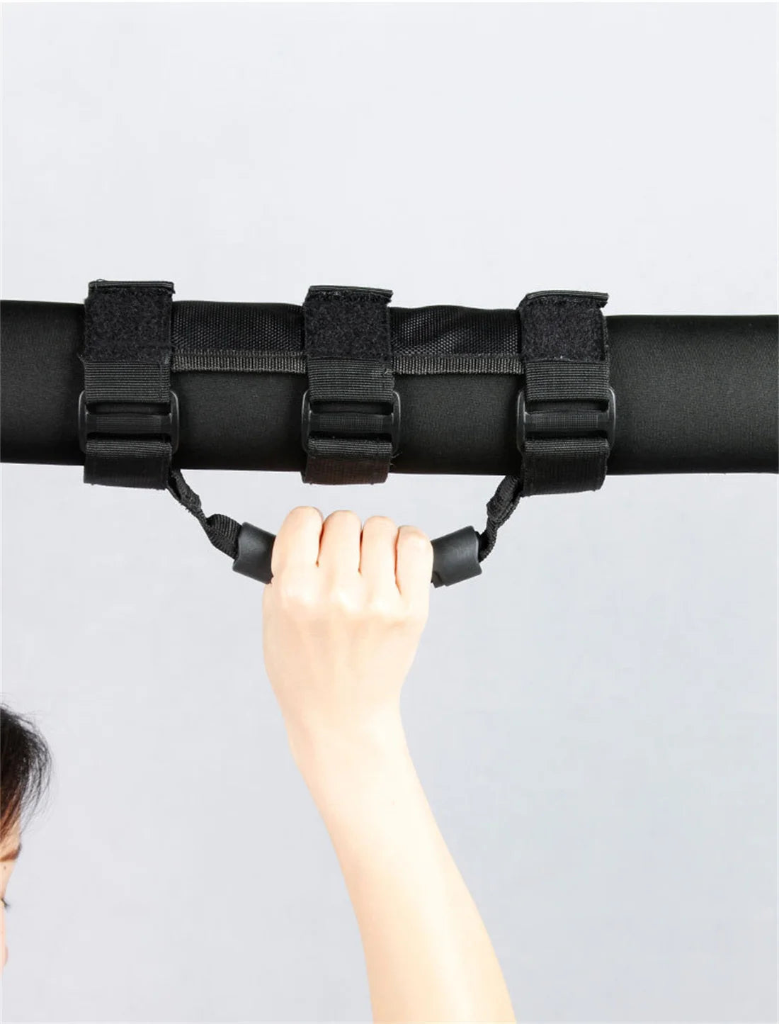 A hand grips a black roll bar grab handle on a vehicle.